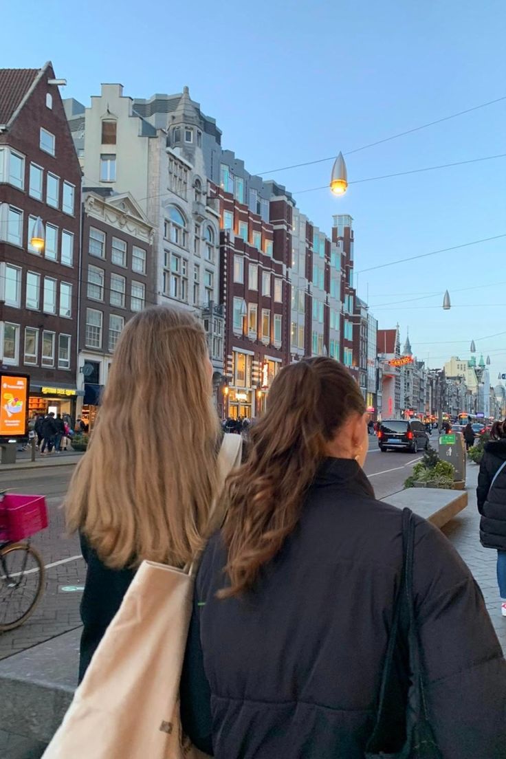 two women are walking down the street