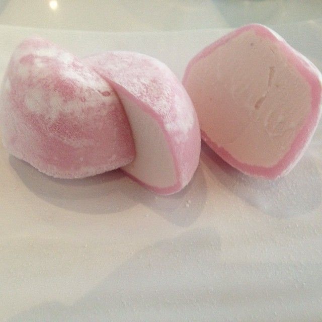 two pieces of pink and white marshmallow sitting on top of a table next to each other