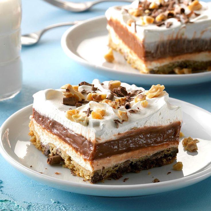 two pieces of cake sitting on top of white plates next to a glass of milk