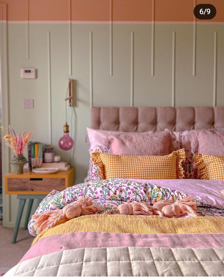 a bed with pink and yellow comforters in a bedroom