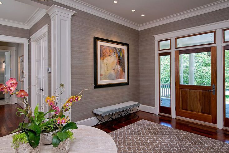 a vase with flowers sitting on top of a table in front of a door way