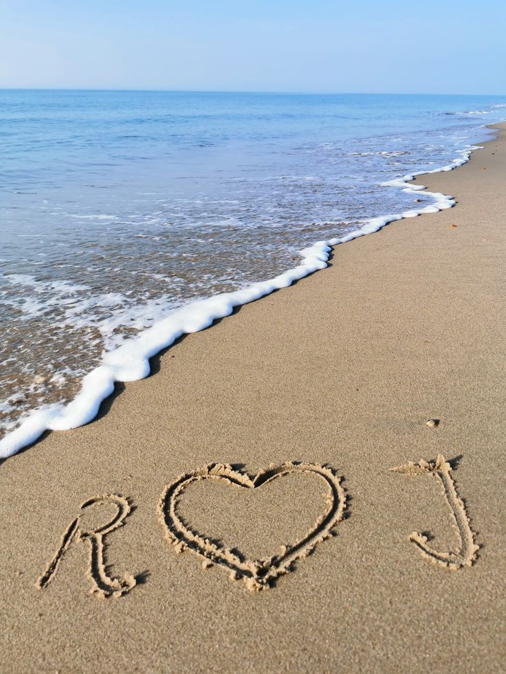 i love you written in the sand at the beach with waves coming in to shore