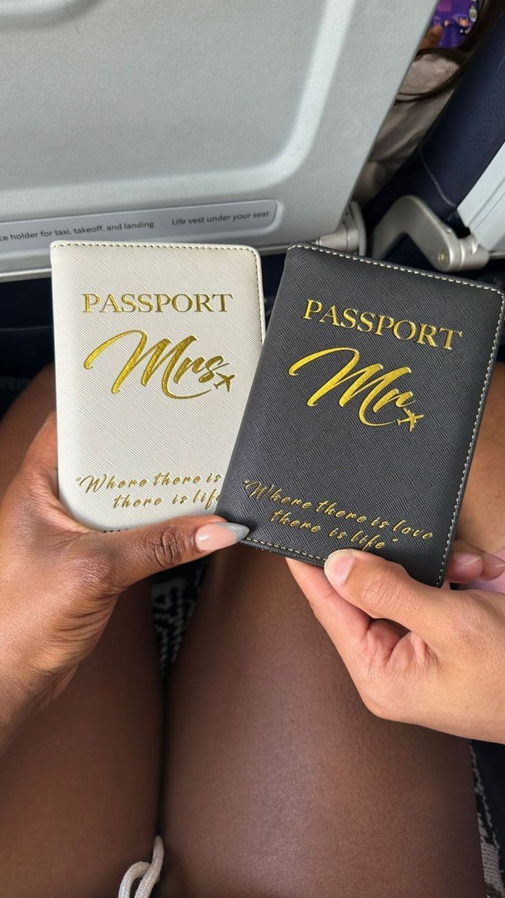 two people holding passports in their hands on an airplane with the seat back facing them