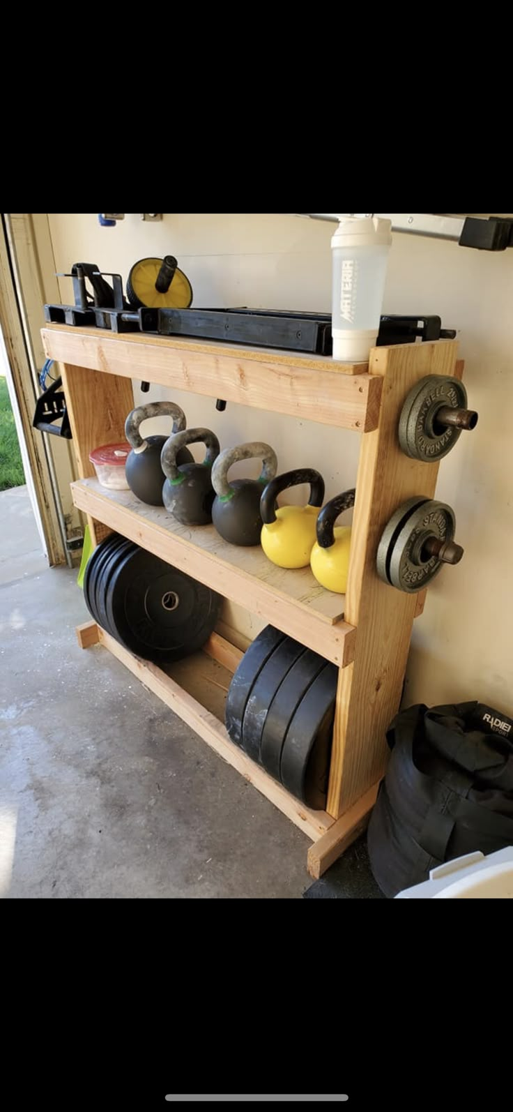 a wooden rack with dumbs and plates on it