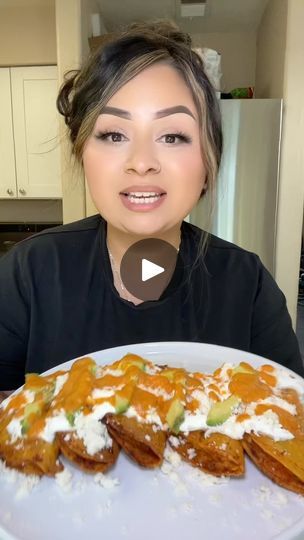 a woman sitting in front of a white plate with food on it