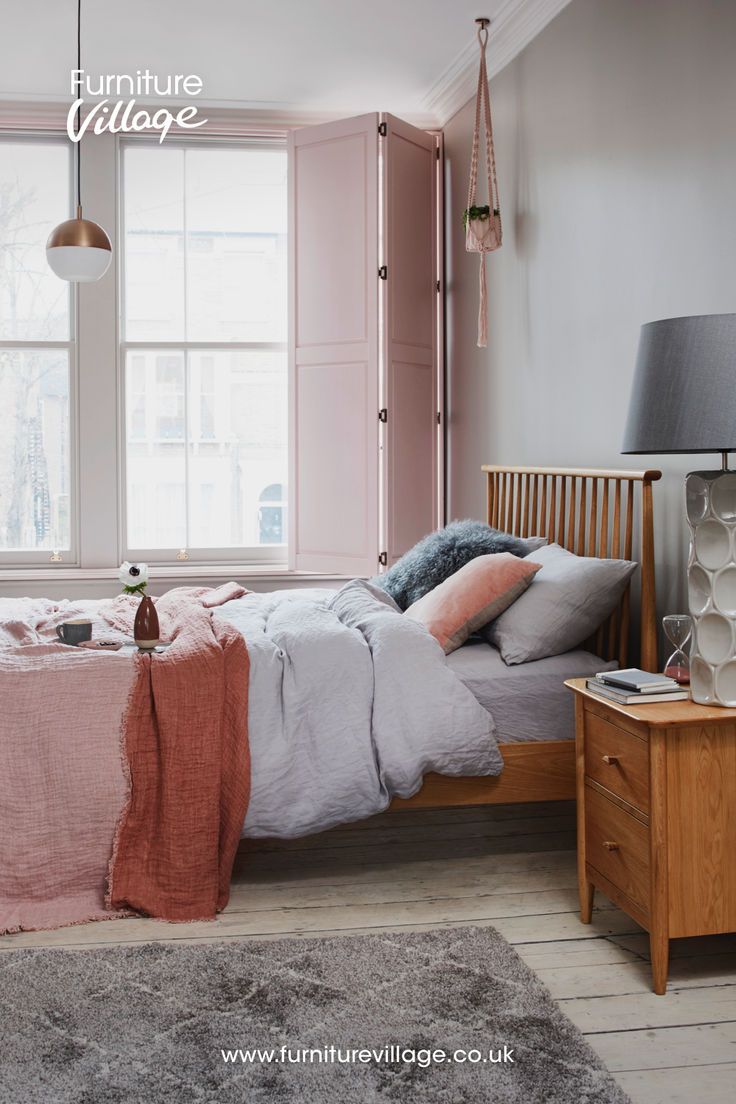 a bed room with a neatly made bed next to a window and a night stand