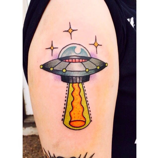 an alien spaceship tattoo on the arm