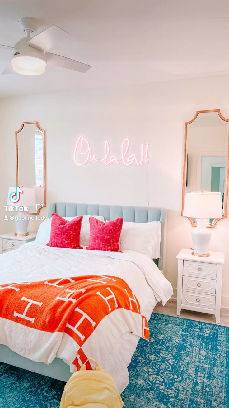 a bedroom with a bed, dresser and mirror on the wall that says oh la la