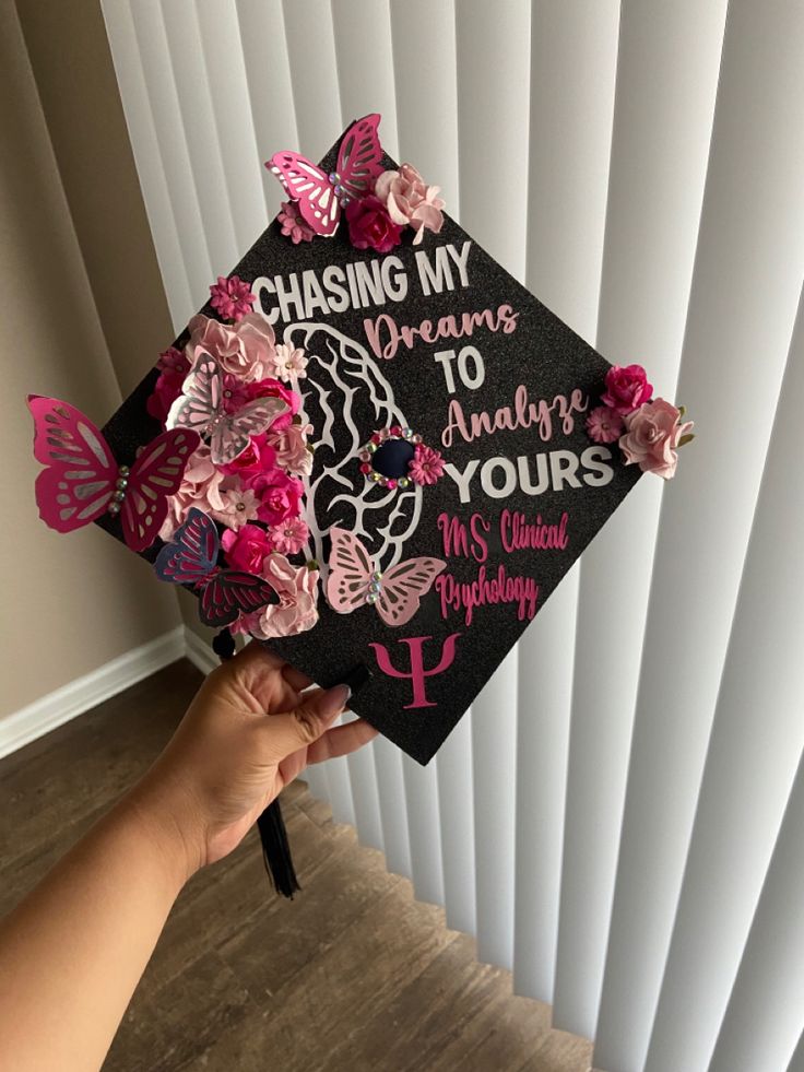 a hand holding a graduation cap with butterflies on it and the words chasing my dreams to always yours