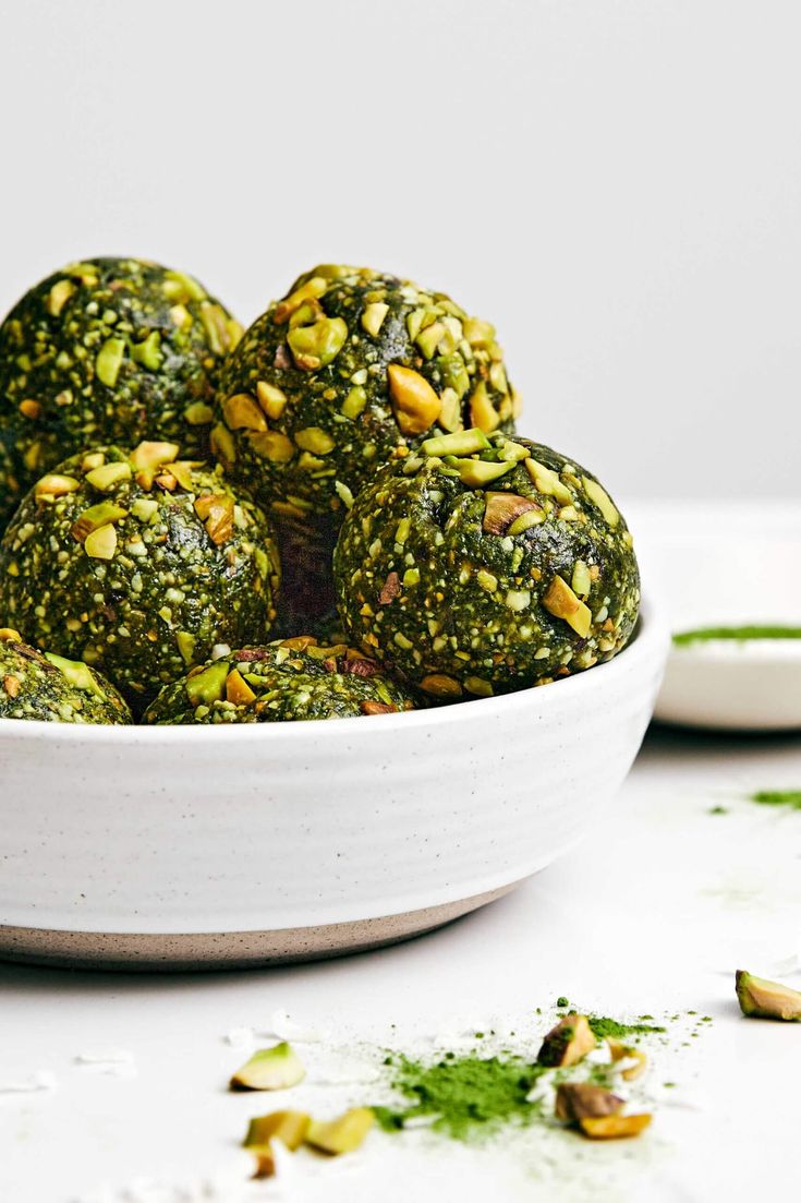 a white bowl filled with pesto balls on top of a table