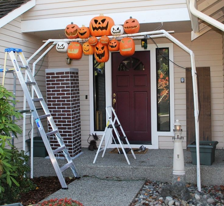 a house decorated for halloween with pumpkins and jack - o'- lanternes