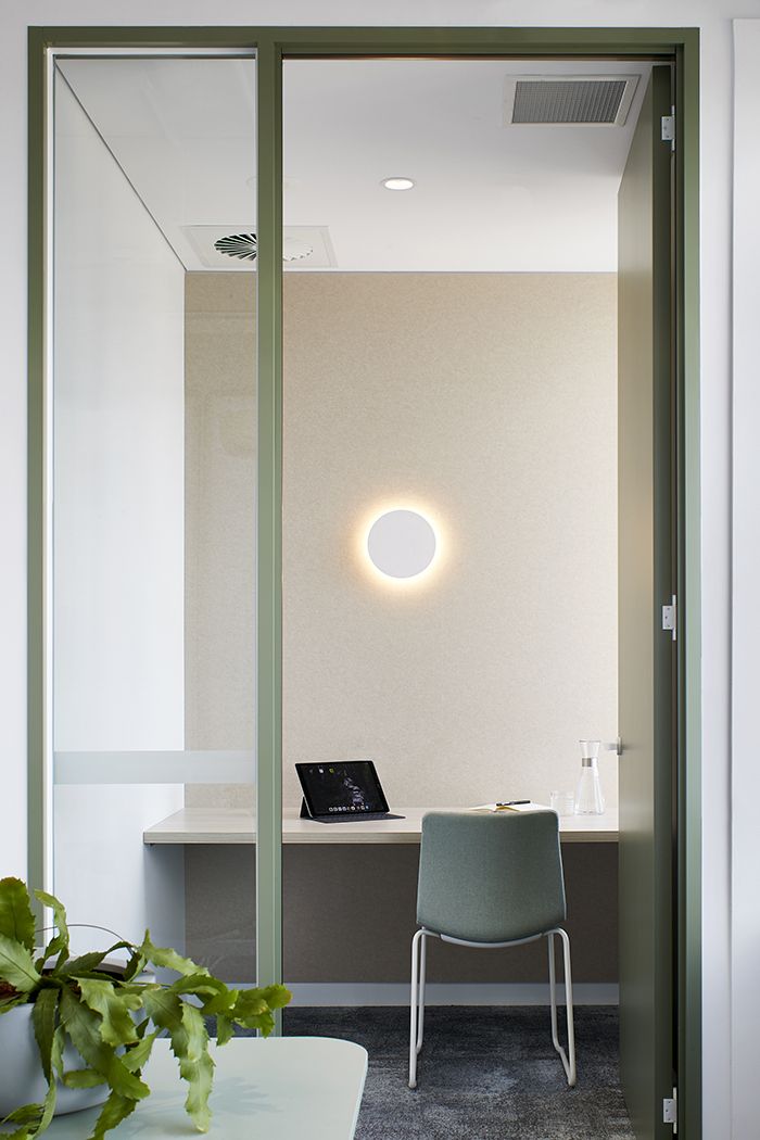 a chair sitting in front of a laptop computer on top of a white desk next to a plant