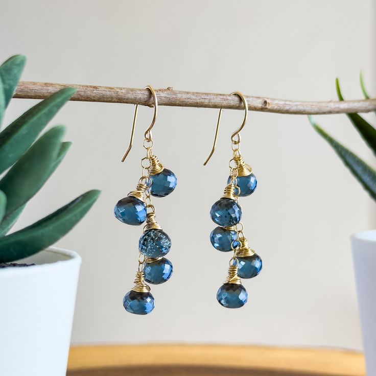 These mesmerizing handmade gemstone earrings are handcrafted with love and attention to detail using stunning London Blue Quartz gemstone onion-shaped briolettes. Each Quartz briolette is intricately wire wrapped using 14k gold-filled wire. Click here to see our full line of handmade gemstone earrings: https://www.etsy.com/shop/wanderlustdesigntx/?section_id=36954387 Dangling gracefully from a central 14k gold-filled chain, these earrings are perfectly dainty with an essence of classic elegance, Handmade Drop Linear Earrings For Gift, Handmade Drop Earrings For Gifts, Handmade Blue Cluster Earrings For Gift, Gemstone Dangle Cluster Earrings As Gift, Earrings Wire, Gemstone Jewelry Handmade, Blue Quartz, London Blue, Gemstone Earrings