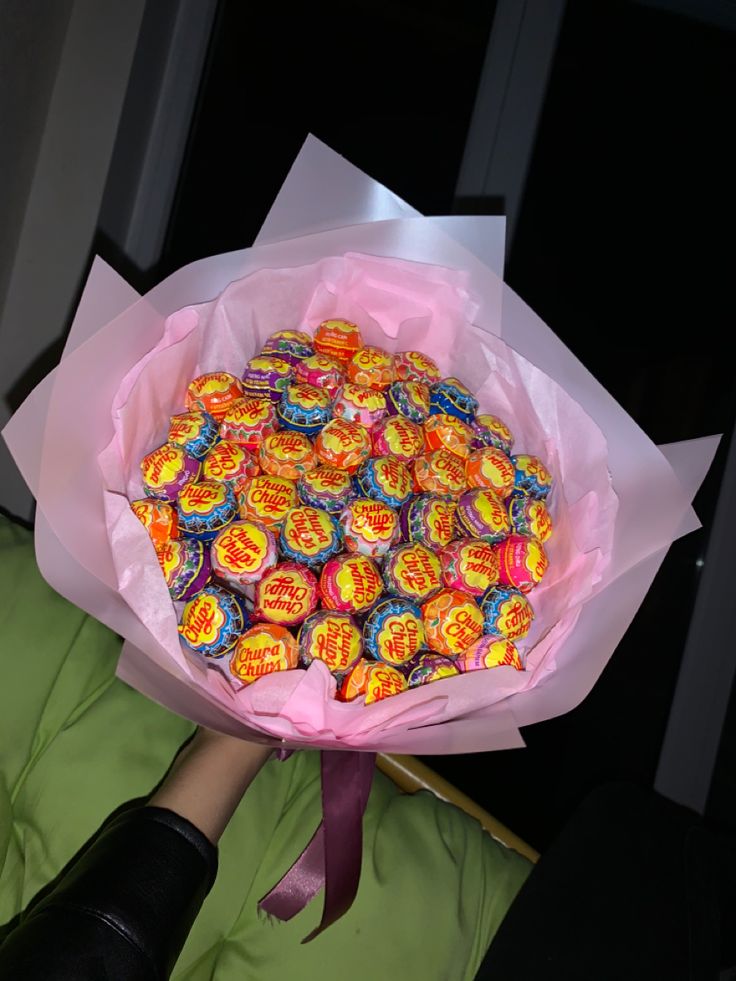 a woman holding a bouquet of colorful candies