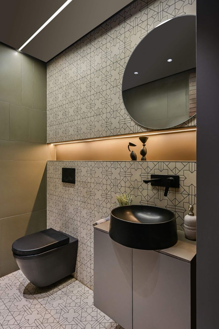 a bathroom with a toilet, sink and round mirror in it's center wall