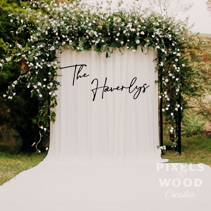 a white backdrop with flowers and the words the happilys written in black on it