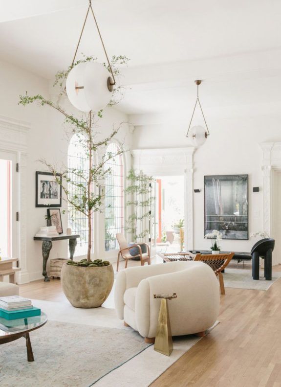 a living room filled with furniture and a tree in the middle of it's center