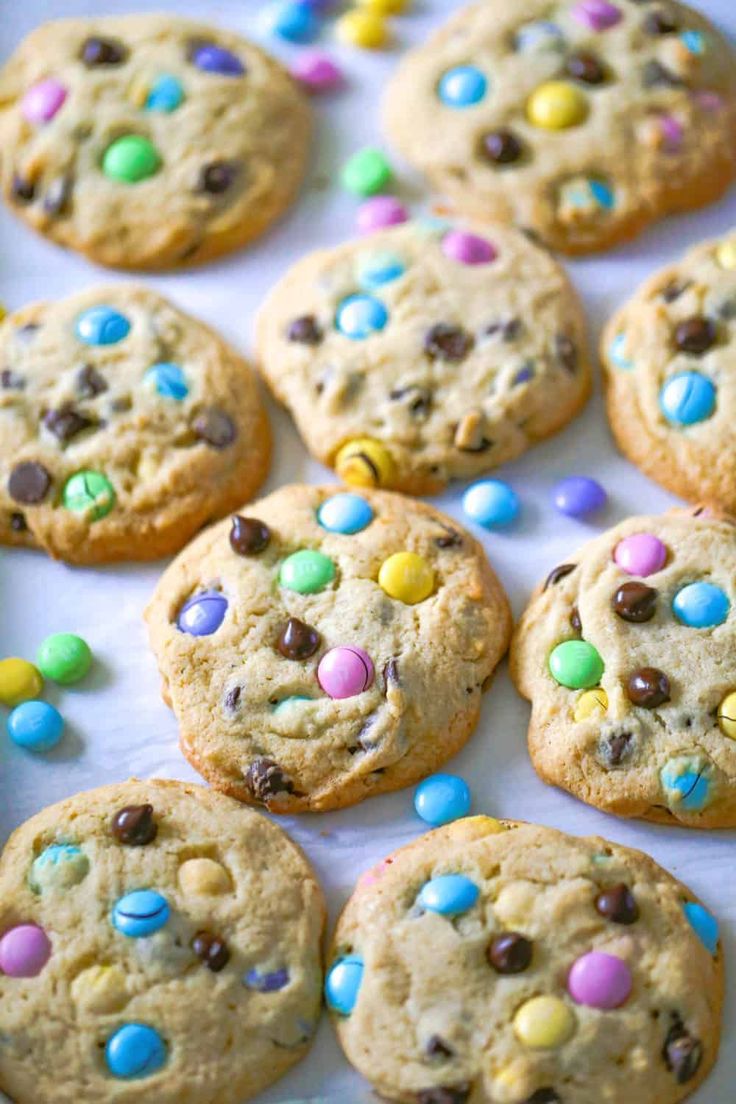 chocolate chip cookies with candy and m & m chips on the top are ready to be eaten