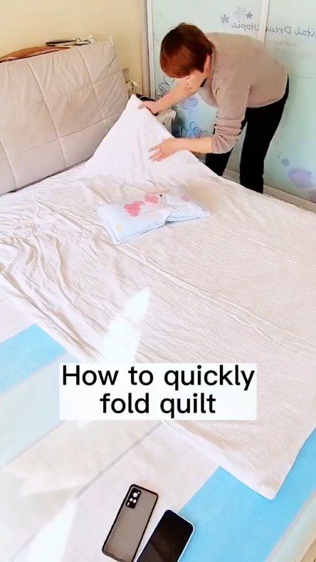 a woman is placing an unmade bed sheet on top of it with the words how to quickly fold quilts