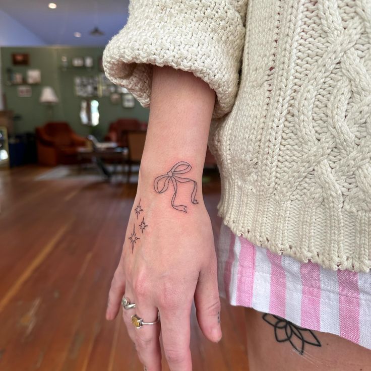 a woman's hand with a small tattoo on it