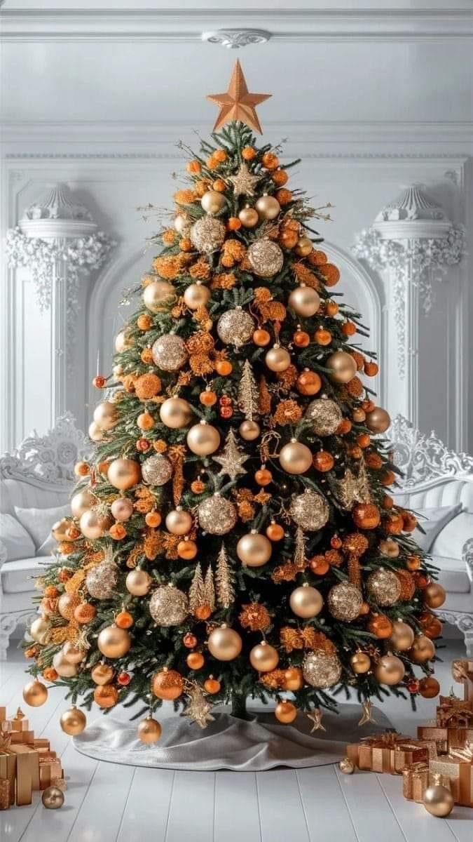 a decorated christmas tree with orange and gold ornaments on it, surrounded by golden wrapped presents