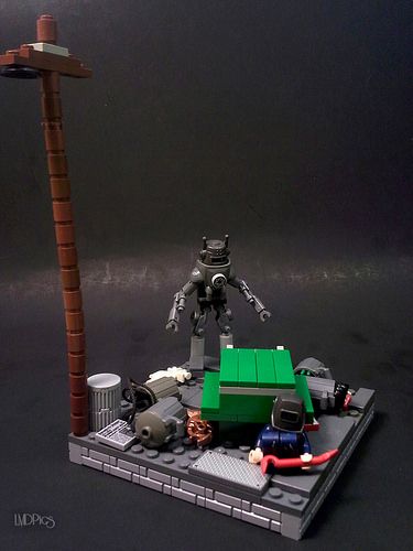 a lego robot standing on top of a table next to a piece of green material