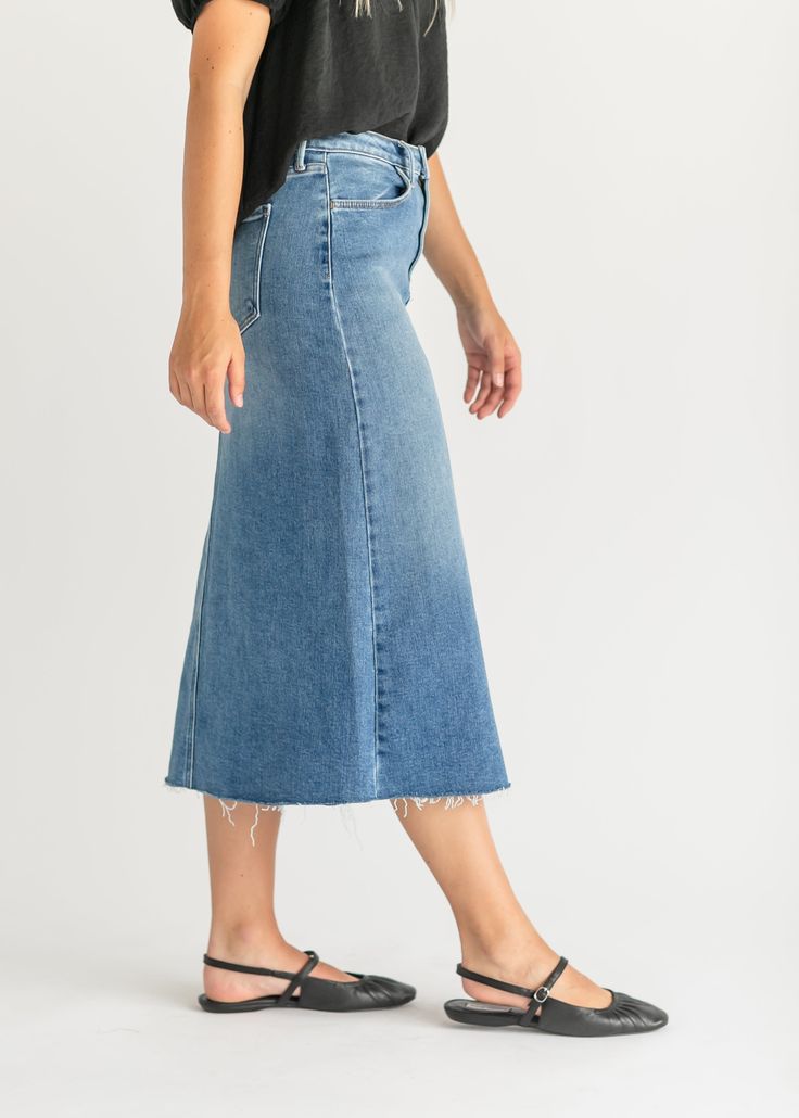 Let us introduce you to the denim skirt you'll want to wear with everything, the Lee A-Line Raw Hem Midi Skirt! This stunning midi denim skirt is an Inherit Design made in the USA! Crafted from high quality, stretchy, medium wash denim that is super soft and will keep you comfortable all day long. The A-line fit is walkable, modest, and on-trend with a raw hem. This sustainable, modest, American-crafted skirt is a true seasonless staple you will wear for years to come! Style | Midi, Denim Color Spring Mid-rise Stretch Skirt, Fall Knee-length Denim Skirt, Fall Denim Knee-length Skirt, Spring Straight-leg Skirt With Frayed Hem, Straight Leg Skirt With Frayed Hem For Fall, Spring Straight Leg Skirt With Frayed Hem, Knee-length Medium Wash Skirt For Fall, Spring Mid-rise Stretch Denim Skirt, Trendy Wide-leg Skirt With Frayed Hem