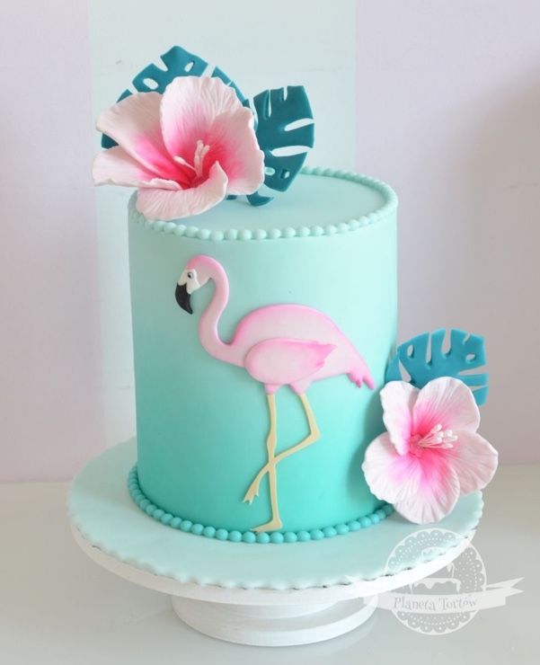 a blue cake with pink flowers and a flamingo on top