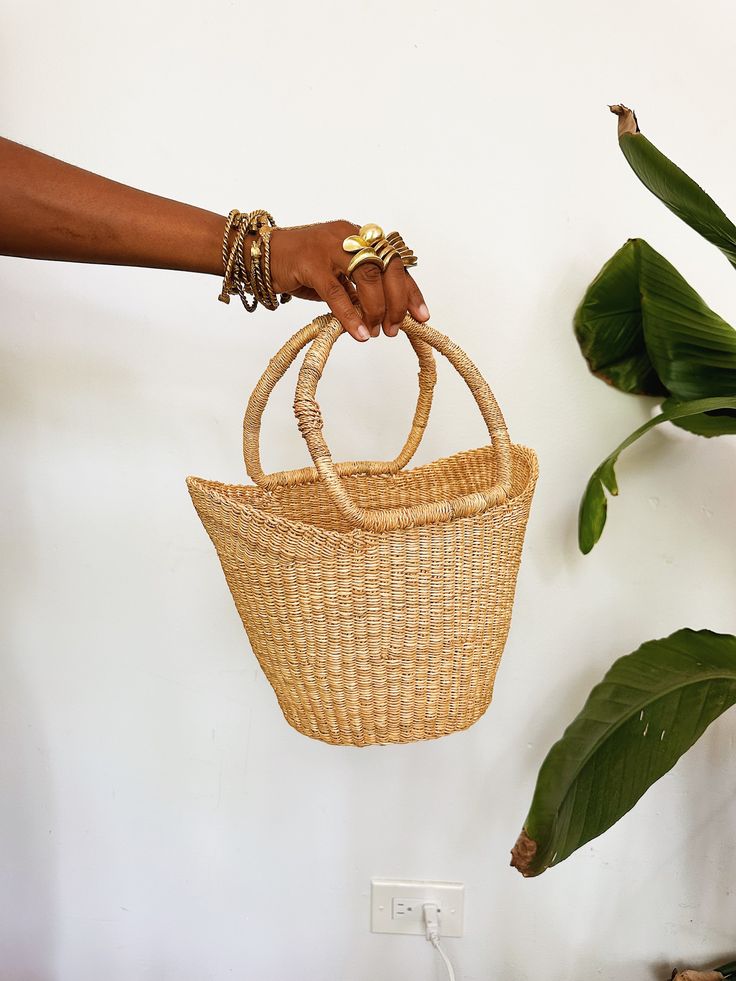 A beautiful authentic one-of-a-kind handwoven basket tote handmade in Bogatanga. Each bag is beautifully woven by hand with thick, natural and dyed elephants grass to create a beautiful pattern and leather wrapped handles. Size: 13”H x 12”W, 6”base. Size may vary slightly. *One-of-a-kind, 1 of 1. Natural Bucket Bag With Braided Handles For Market, Natural Top Handle Bucket Bag For Market, Top Handle Natural Bucket Bag For Market, Handwoven Natural Straw Bag With Top Handle, Natural Handwoven Top Handle Straw Bag, Natural Top Handle Beach Bag For Market, Handmade Natural Fiber Bucket Bag For Market, Artisan Straw Bucket Bag With Leather Handles, Handmade Basket Bucket Bag For Market