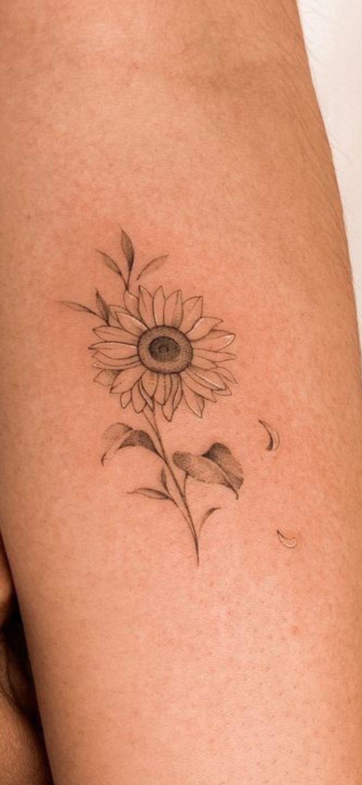 a woman's thigh with a sunflower tattoo on it