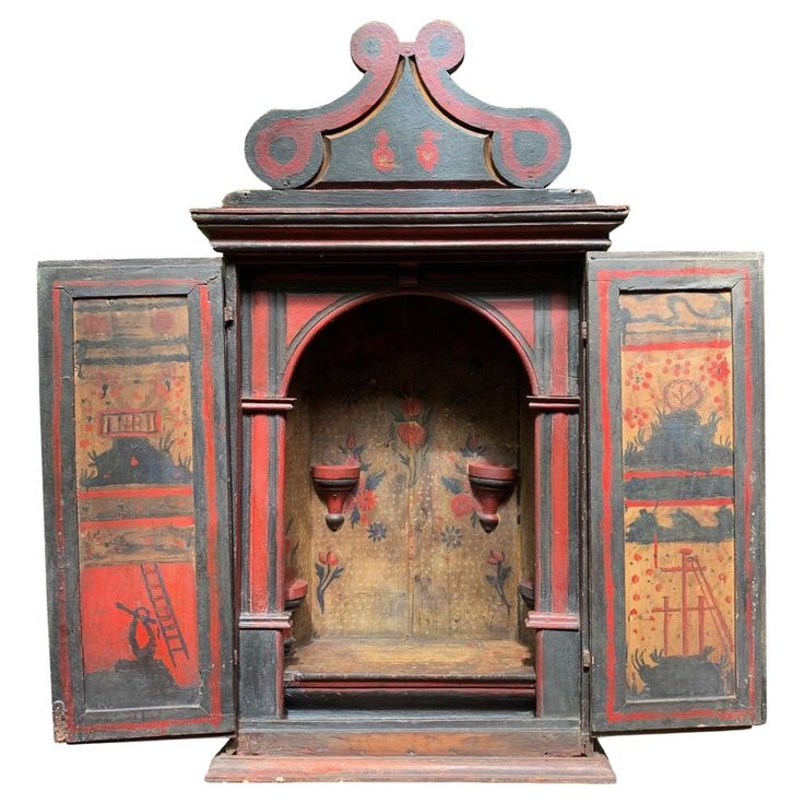 an old wooden cabinet with painted designs on the front and back doors, open to reveal a fireplace