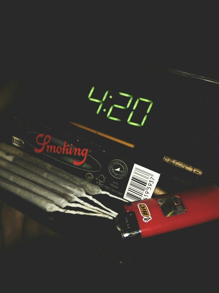 an alarm clock sitting on top of a desk next to pencils