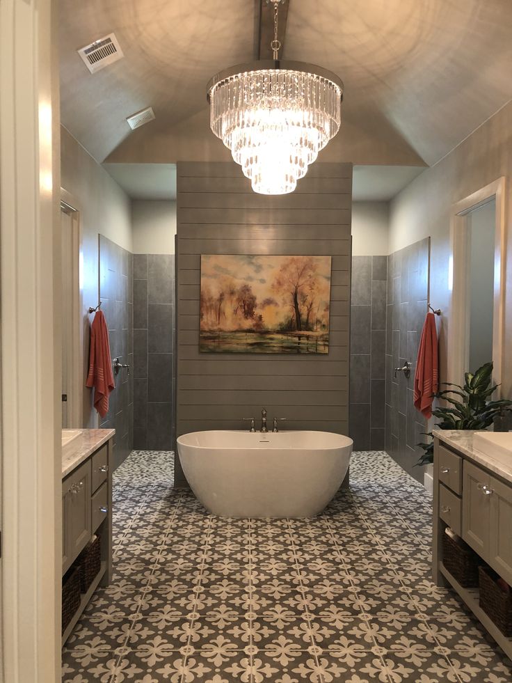 a bath room with a large tub and a chandelier hanging from the ceiling