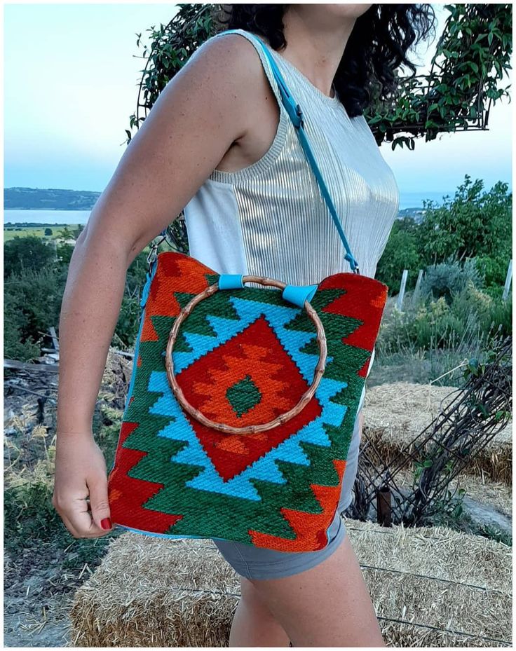 The vibrant colors and unique ethnic patterns on this carry-all bag make it a practical and fashionable accessory. Made from durable kilim - carpet - rug fabric, this day bag is great when you are out and about. Treat yourself, or give as a gift. With a geometric pattern and cute bamboo shape handles, It can be carried as a tote or worn over the shoulder or crossbody, with the adjustable strap making it really practical as well as stylish. wool and cotton mix kilim fabric, We use and also an inn Bohemian Shoulder Bag With Round Handle, Green Bohemian Handheld Bag, Bohemian Tote Bag With Bamboo Handle, Bohemian Shoulder Bag With Bamboo Handle, Bohemian Rectangular Shoulder Bag With Bamboo Handle, Multicolor Tote Bag With Bamboo Handle, Bohemian Shoulder Bag With Detachable Handle, Bohemian Shoulder Bag With Round Handle For Daily Use, Bohemian Green Shoulder Bag With Double Handle