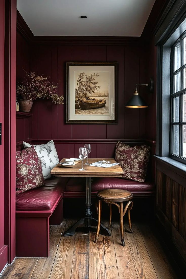 a table and bench in a room with red walls