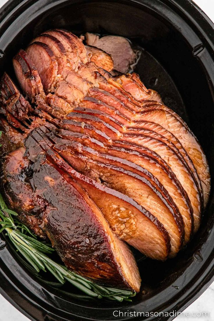 roasting meat in the slow cooker with rosemary garnish on top, ready to be cooked