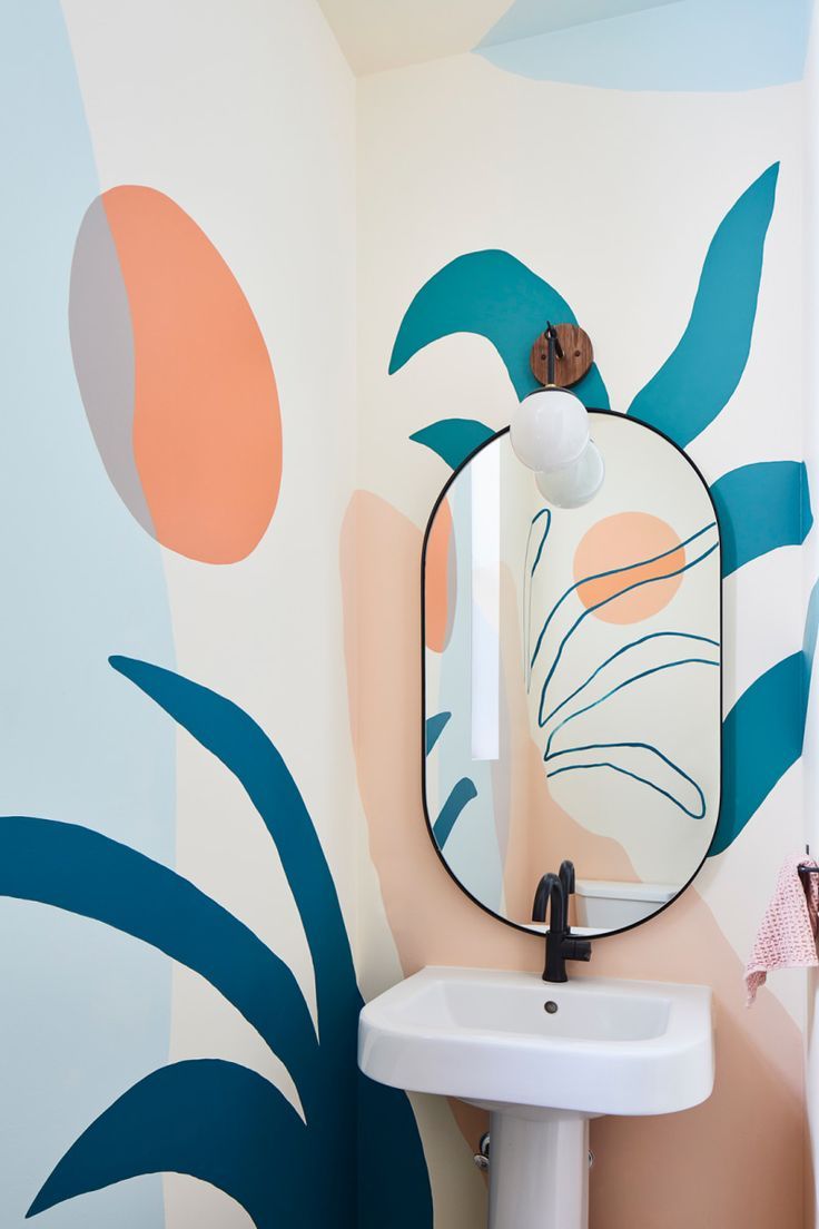 a bathroom with a sink, mirror and palm leaf wallpaper on the walls behind it