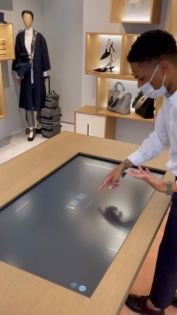 a man wearing a face mask is looking at a display case with shoes on it