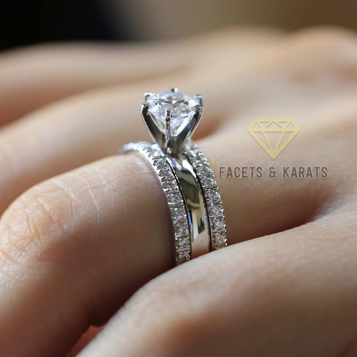 a woman's hand with a diamond ring on top of her finger and the wedding band