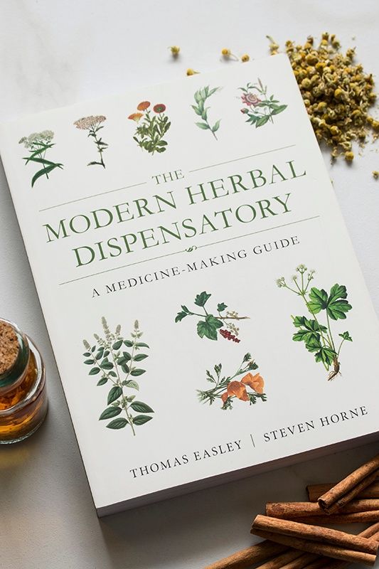 the modern herb dispensary book next to some cinnamon sticks and anise