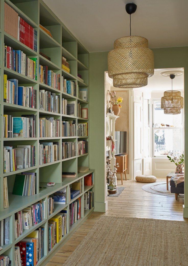 a room filled with lots of books on top of shelves next to a door way