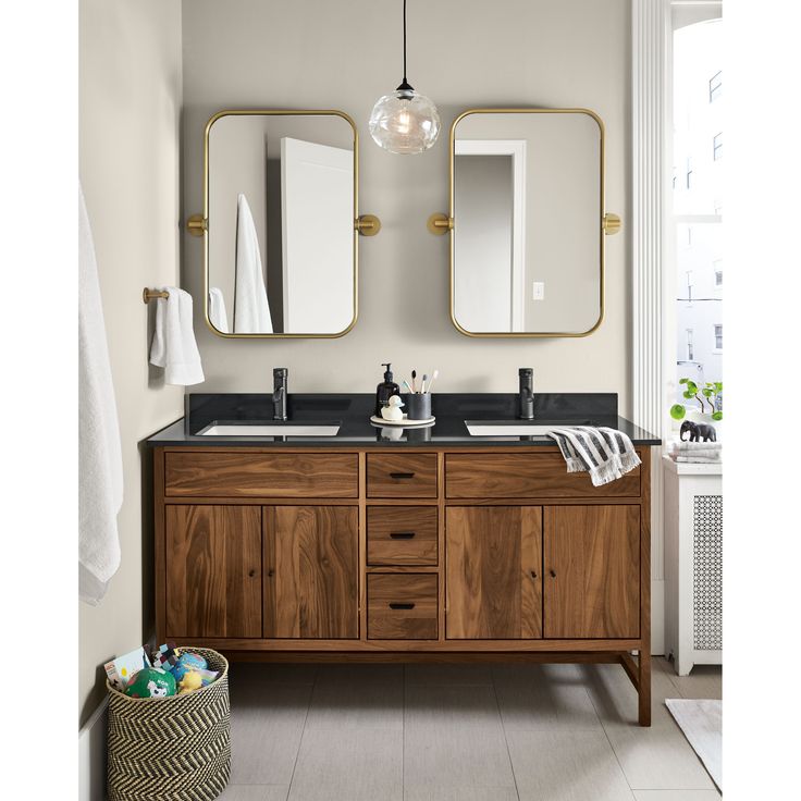 a bathroom with double sinks and two mirrors