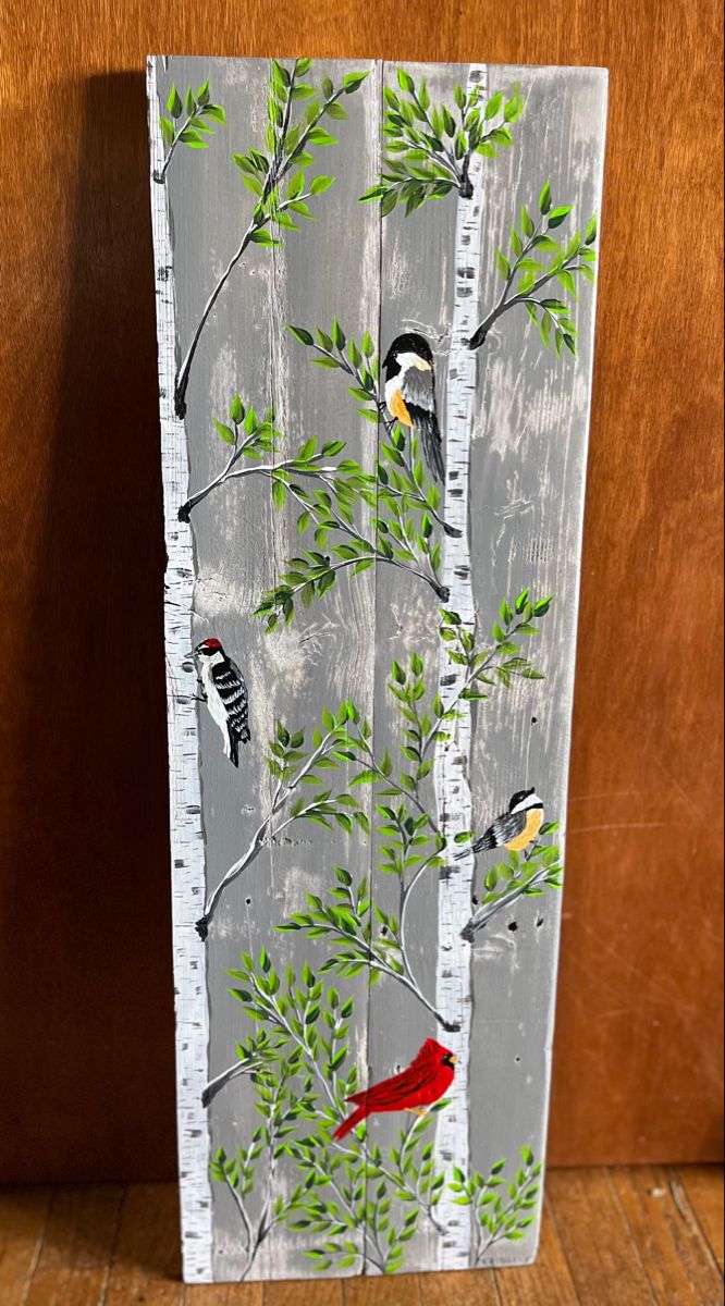 a painting of birds on a tree with leaves and branches painted on the side of it