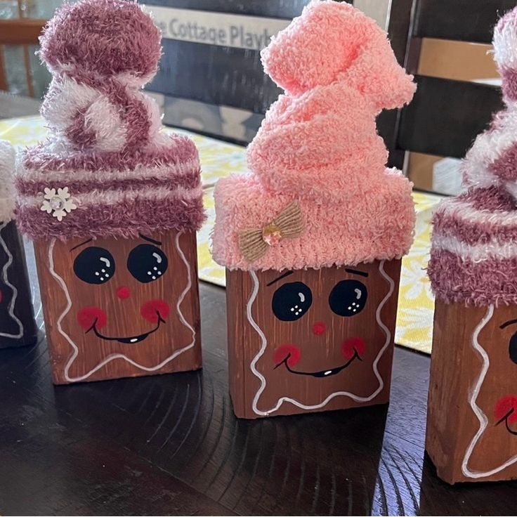 three small cupcakes with faces painted on them are sitting on a wooden table