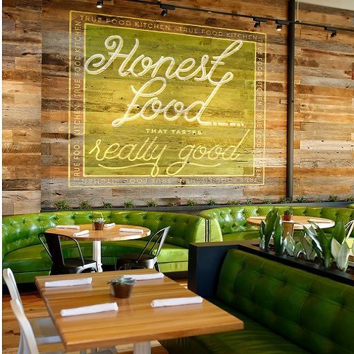 the interior of a restaurant with green booths and wooden walls that say fresh food, really good