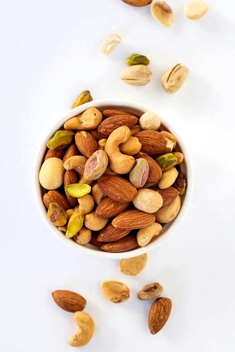 a bowl filled with nuts on top of a white table