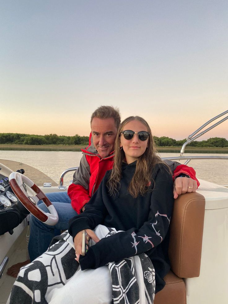 two people sitting on a boat in the water