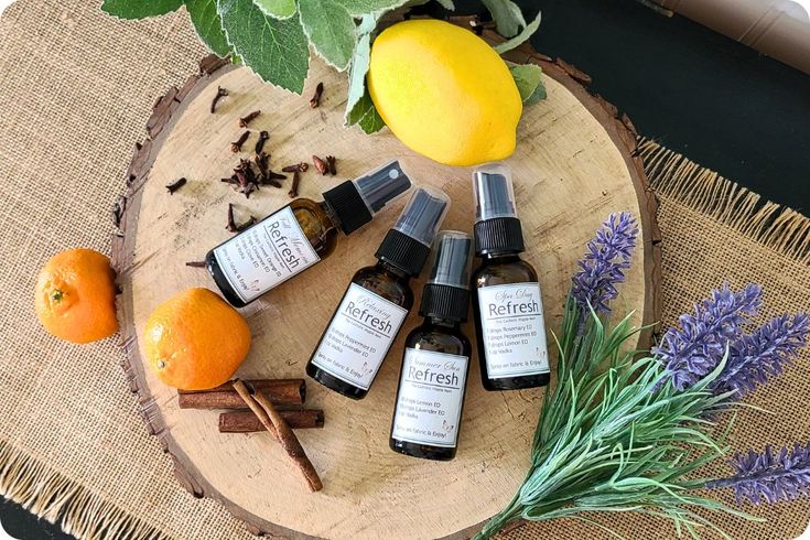 an assortment of essential oils sitting on top of a wooden table next to oranges and lavender