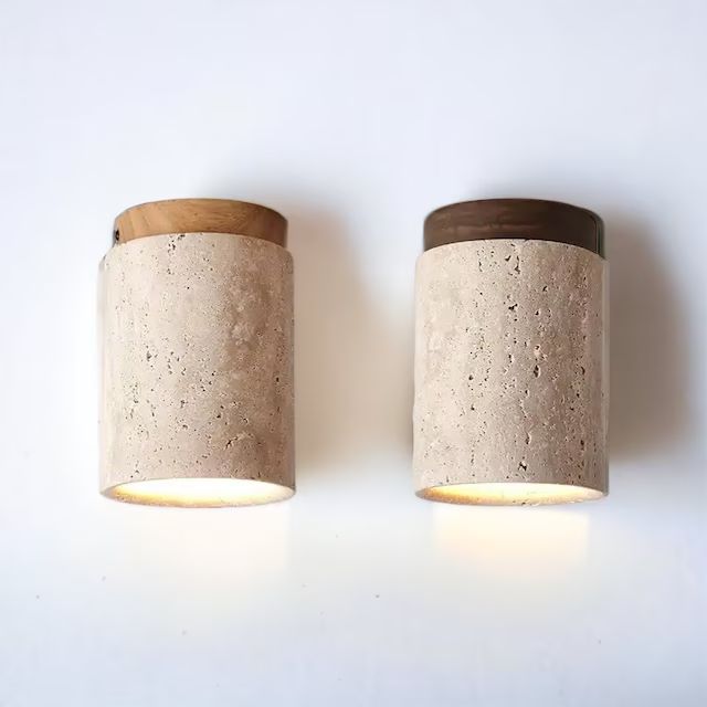 two concrete lights are on the wall next to each other