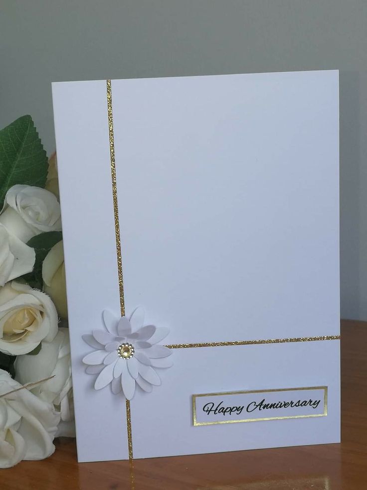 a bouquet of white flowers sitting on top of a table next to an open card